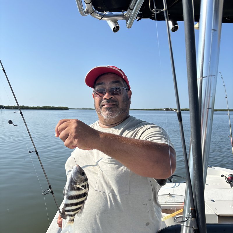 Redfish catch held over the boat gunwale on a New Smyrna Beach fishing charter